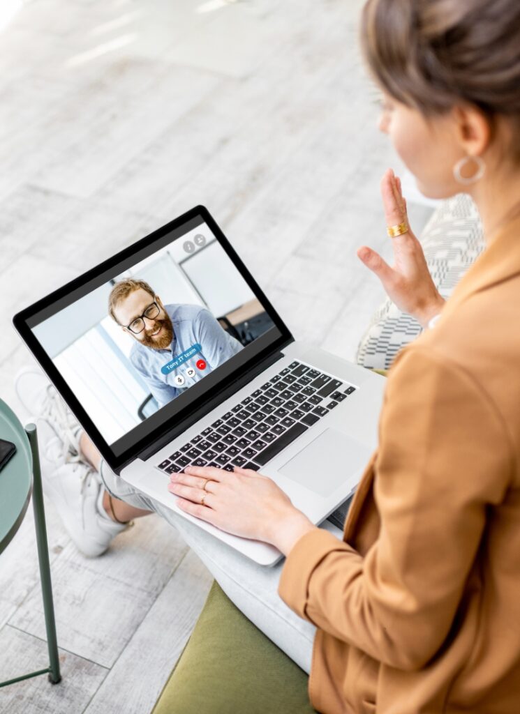 A couple sits together on a sofa, participating in a video call with a doctor on their laptop, illustrating the accessibility and flexibility of telemedicine services.