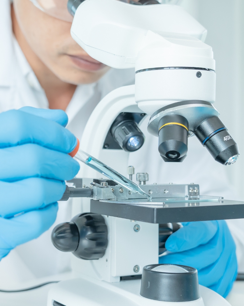 Scientist using a pipette and microscope for advanced laboratory testing