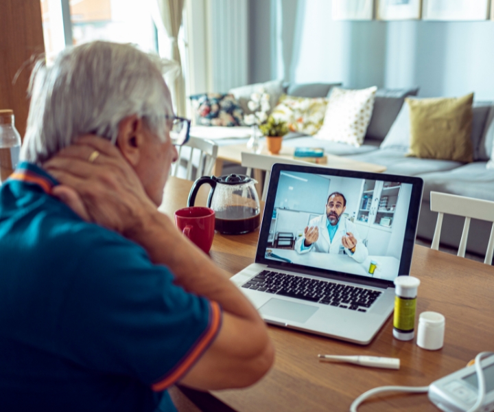 Senior man having an online medical consultation via video call at home