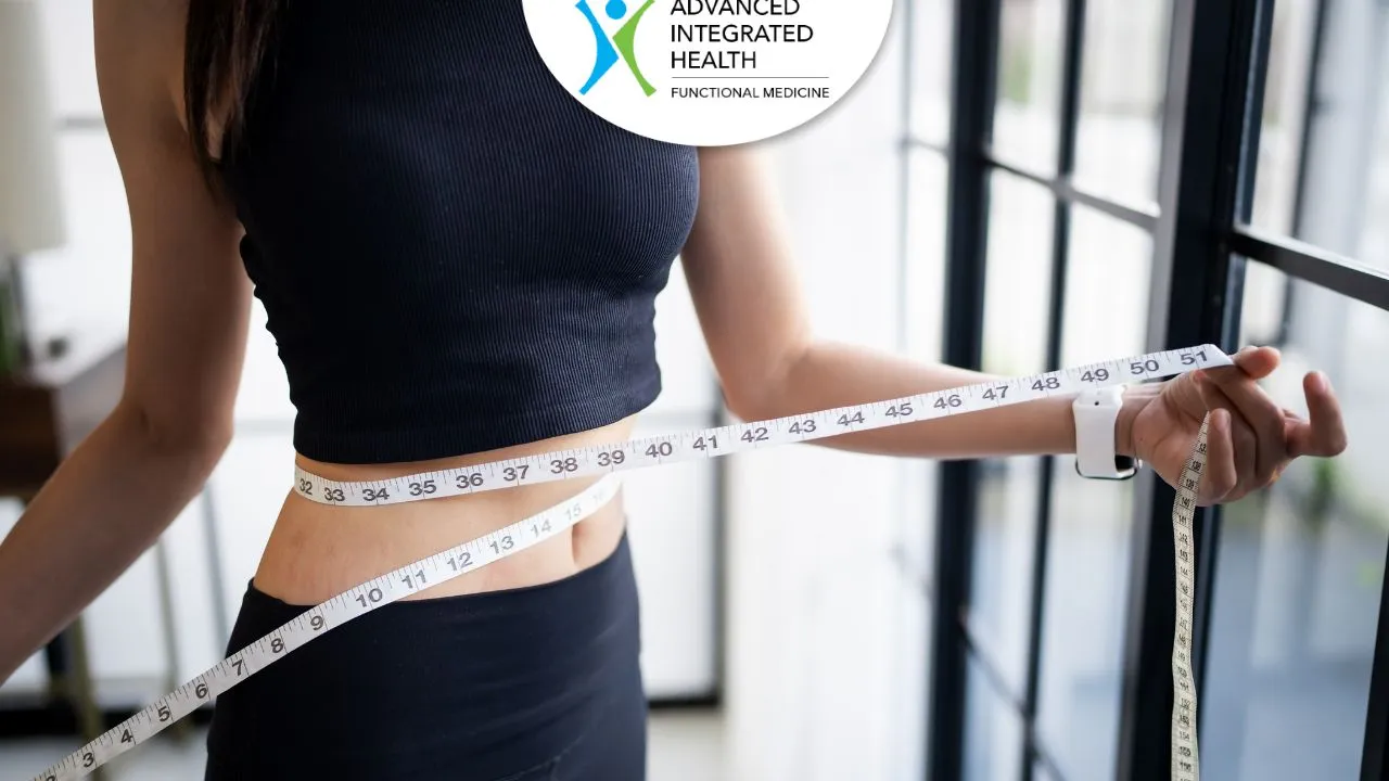 Woman measuring her waist to track weight loss progress