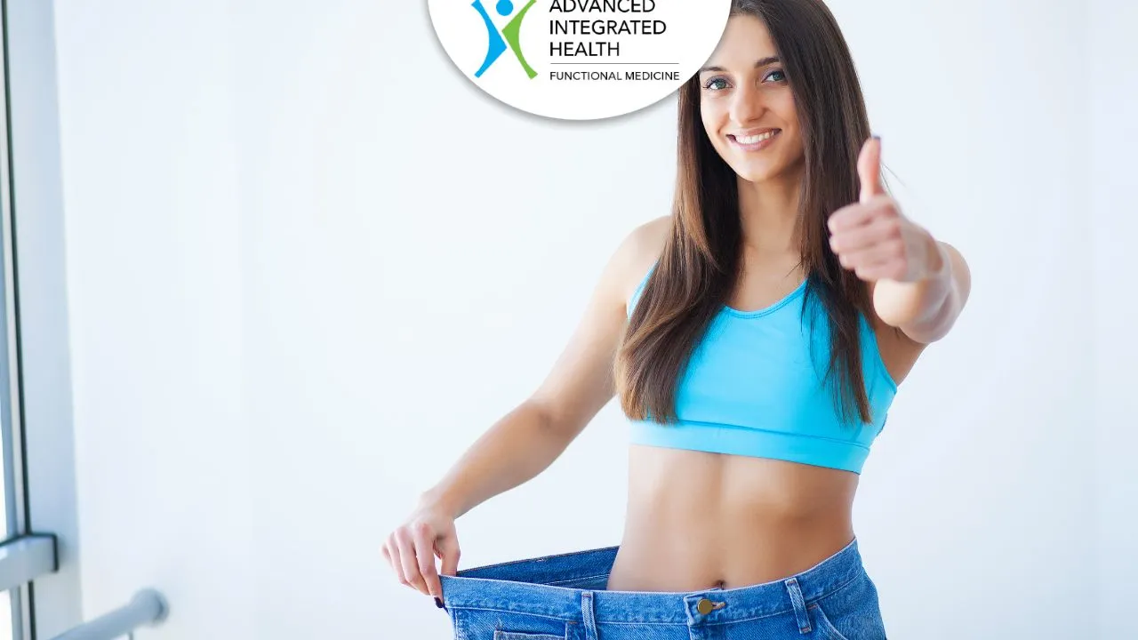 Woman in loose jeans showing weight loss results