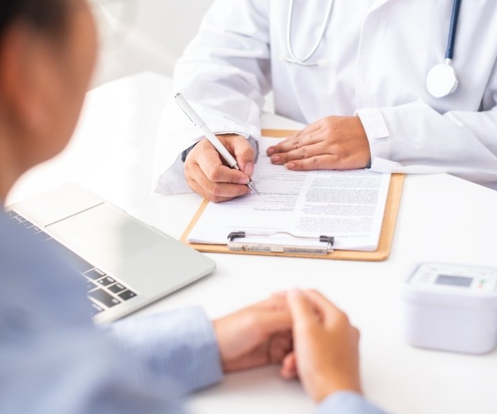 Doctor writing patient's information during consultation