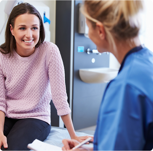 Smiling female patient in a consultation with a healthcare professional at Advanced Integrated Health, discussing personalized wellness care.