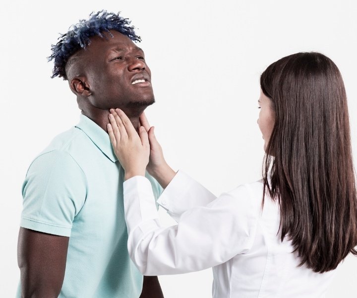 Doctor checking man's throat for thyroid disorder issue