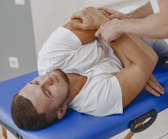 Chiropractor performs spinal adjustment on patient lying on their side during a chiropractic care session